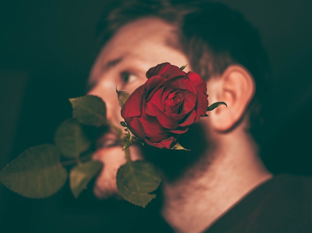 Man (blurred) with a rose in his mouth. Man (vervaagd) met een roos in zijn mond.